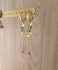 18K gold plated hoop earrings with Peridot green butterflies and clover displayed on jewellery stand