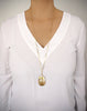 Woman wearing a long dragonfly necklace with a Golden Shadow Swarovski crystal pendant