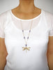 Woman wearing a long 18K gold plated dragonfly necklace with Tanzanite Swarovski crystals