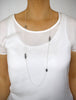 Woman wearing a long silver necklace with Black Silver Night Swarovski crystals