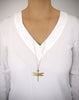 Woman wearing a long 18K gold plated dragonfly necklace with a Tanzanite Swarovski crystal