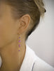 Woman earing long-length 18K gold plated earrings with Amethyst Swarovski crystals