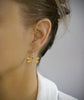 Woman wearing 18K gold plated dragonfly earrings with Tanzanite crystals