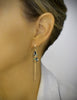 Woman wearing long-length gold plated hoop earrings with Black Silver Night drops