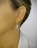 Woman wearing hodium plated earrings with grey freshwater pearls and clear Swarovski crystal butterflies