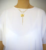 Woman wearing a medium-length triple chain 18K gold plated butterfly Y-necklace.