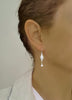 Woman wearing rhodium plated flowerlink earrings with clear Swarovski crystals