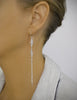 Woman wearing long-length rhodium plated double flowerlink earrings