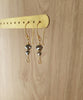 18K gold plated earrings with "Black Silver Night" Swarovski crystals and Golden Shadow charms on display.
