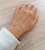Woman wearing 18K gold plated butterfly bracelet adorned with sparkling Tanzanite Swarovski crystals.