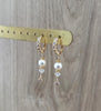 18K goldplated crystal embellished hoop earrings with white pearls and clear crystals on display.