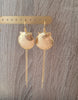 18K gold plated long-length statement seashell earrings on jewellery display.