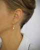 Woman wearing elegant 18K gold plated earrings handmade with Golden Shadow Swarovski crystal drops.