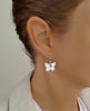 Woman wearing rhodium plated butterfly earrings with Tanzanite Swarovski crystal charms
