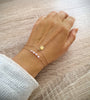 Dige Designs 18K gold plated double chain seashell bracelet decorated with rose freshwater pearls worn on hand
