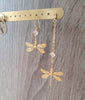 18K gold plated short and long-length dragonfly and crystal earrings on display