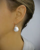 Woman wearing rhodium plated seashell earrings with clear Swarovski crystals