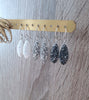 Timeless silver earrings adorned with sparkling white, grey and black Swarovski crystal pavé pendants.