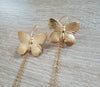 Close up of long-length 18K gold plated statement butterfly earrings.