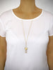 Woman wearing long-length 18K gold plated butterfly necklace adorned with sparkling Golden Shadow Swarovski crystals.