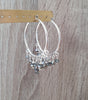 Rhodium plated statement hoop earrings with Black Silver Night Swarovski crystals on jewellery display