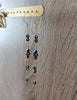 Long-length 18K gold plated earrings with black Swarovski crystals on display