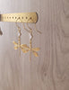  18K gold plated dragonfly and diamond-cut crystal earrings on jewellery display