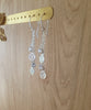  Rhodium plated swirl coin earrings handmade with Swarovski crystals on display