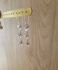 Rhodium plated swirl coin earrings with Swarovski crystals on display
