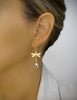 Woman wearing 18K gold plated dragonfly earrings with "Golden Shadow" Swarovski crystal drops