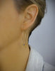 Woman wearing 18K gold plated hoop earrings with butterfies and Swarovski balls