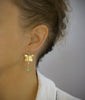 Woman wearing 18K gold plated butterfly stud earrings with Emerald drops