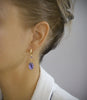 Woman wearing 18K gold plated hoop earrings with Tanzanite Swarovski crystal drops