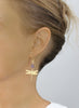 Woman wearing 18K gold plated dragonfly earrings with Tanzanite Swarovski crystal drops.
