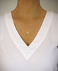 Woman wearing a medium length 18K gold plated necklace with Golden Shadow Swarovski crystal drop.