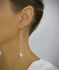 Woman wearing 18K gold plated Long-length dangle earrings with Golden Shadow Swarovski crystals