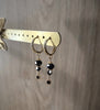 18K gold plated huggie earrings featuring black Swarovski crystals on display