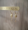 18K gold plated seashell earrings with crystal charms on display