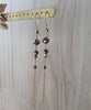 Long-length 18K gold plated earrings with "Black Silver Night" Swarovski crystals on display.