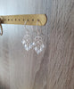 Rhodium plated heart filigree earrings with Blue Shade Swarovski crystals on display