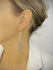 Woman wearing silver dangle earrings with Black Silver Night Swarovski crystals.
