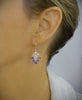 Woman wearing rhodium plated heart filigree earrings with Tanzanite Swarovski crystals
