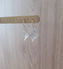 Silver butterfly earrings featuring clear Austrian crystals on display
