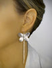 Woman wearing stylish long-length rhodium plated butterfly statement earrings