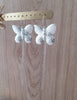 Stylish long-length rhodium plated butterfly statement earrings on display