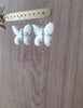 Stylish long-length rhodium plated butterfly statement earrings on jewellery  display
