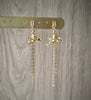 18K gold plated angel earrings with clear crystal earstuds and dangling chains on display