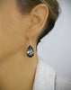 Woman wearing 18K gold plated earrings with "Black Silver Night" Swarovski crystal teardrops.