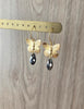 18K gold plated butterfly earrings adorned with "Black Silver Night" Swarovski crystal drops on display.