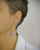 Woman wearing 18K gold plated threader earrings with butterflies and Light Sapphire Swarovski drops.